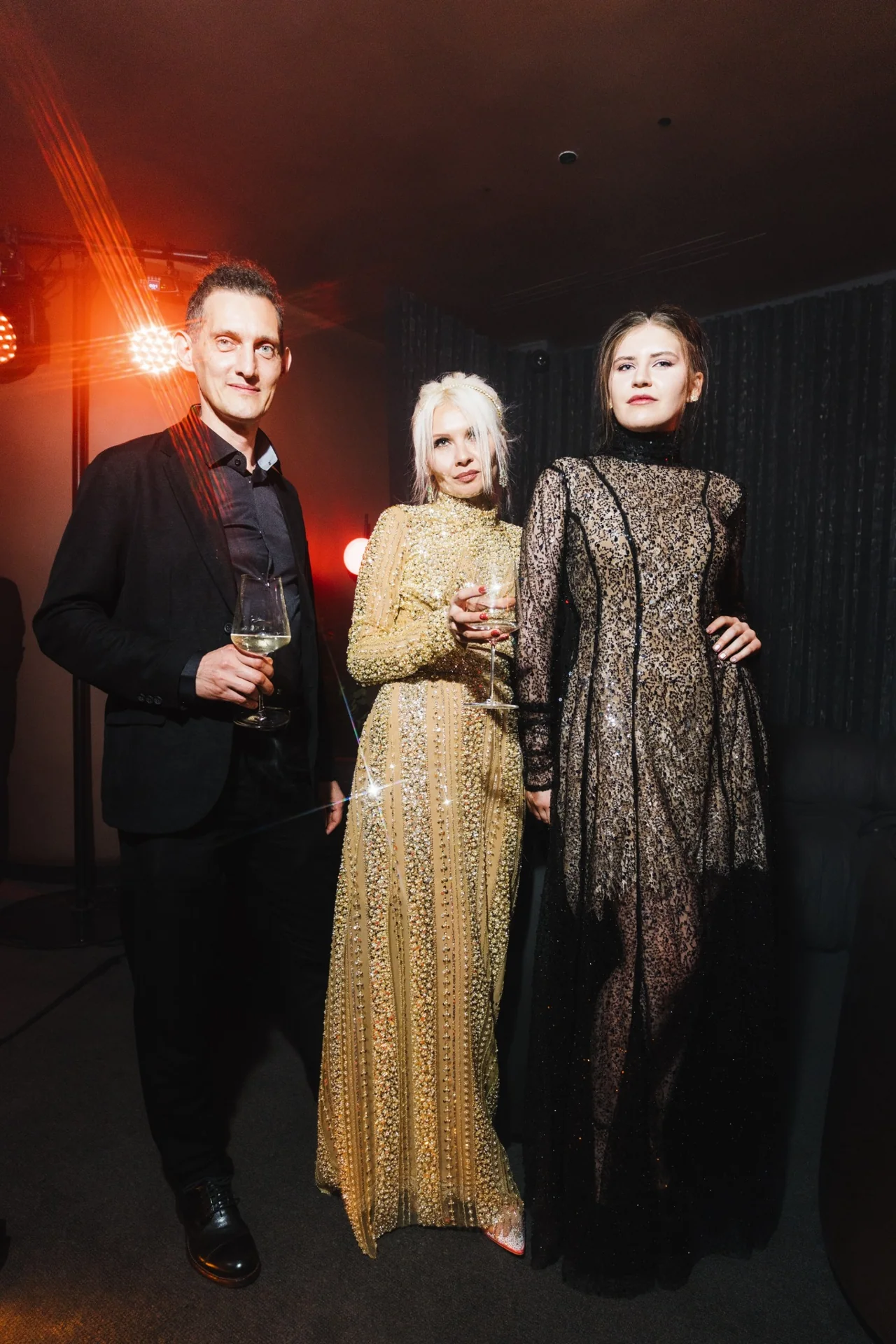 Exemples de tenues de soirée : un homme en costume noir et deux femmes en tenues expressive chic